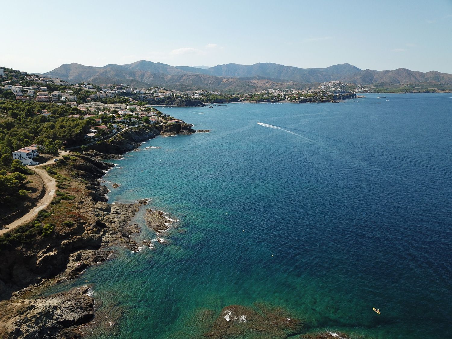 Vistas de agua cristalina y de la costa de Llançà con montañas de fondo